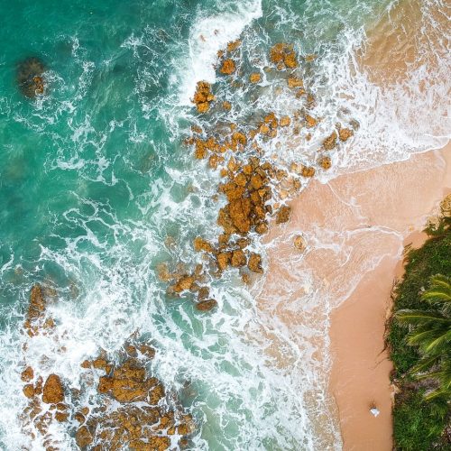 Stunning aerial view of a tropical beach with waves breaking on the sandy shore in Brazil.